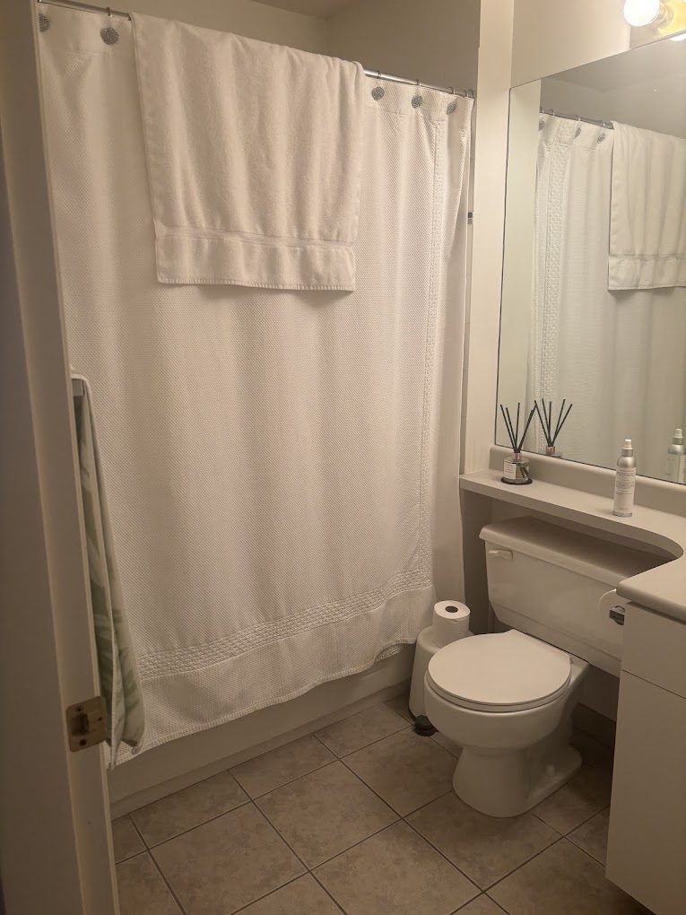 Finished bathroom with new shower, toilet and tile flooring, completed by The Real Handyman