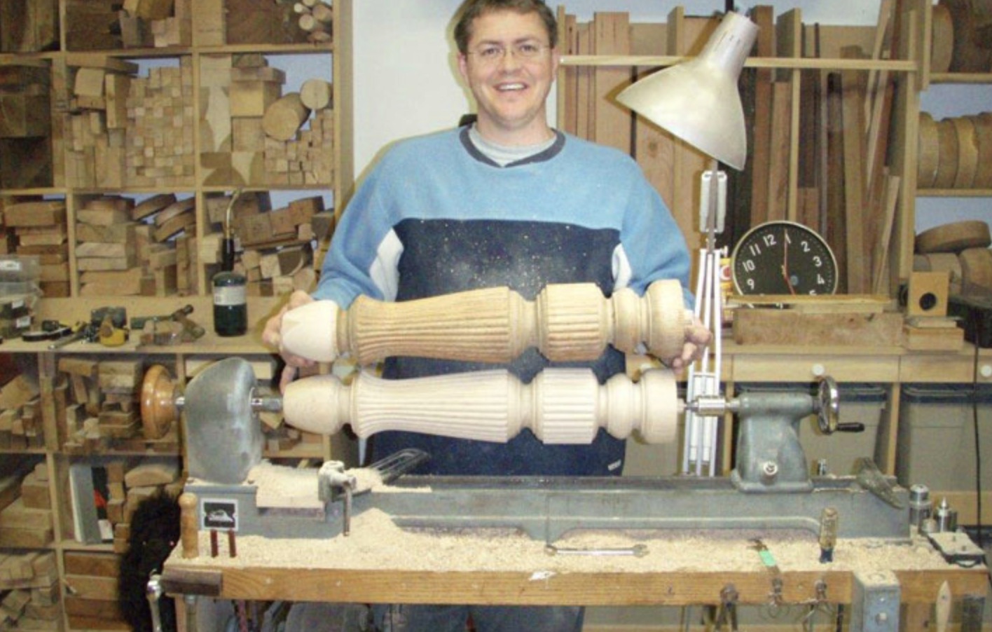 Scott hand-turning wood table legs on a lathe in his workshop