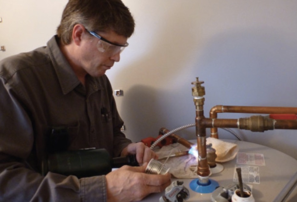 Scott, The Real Handyman, soldering a copper pipe joint on a plumbing repair